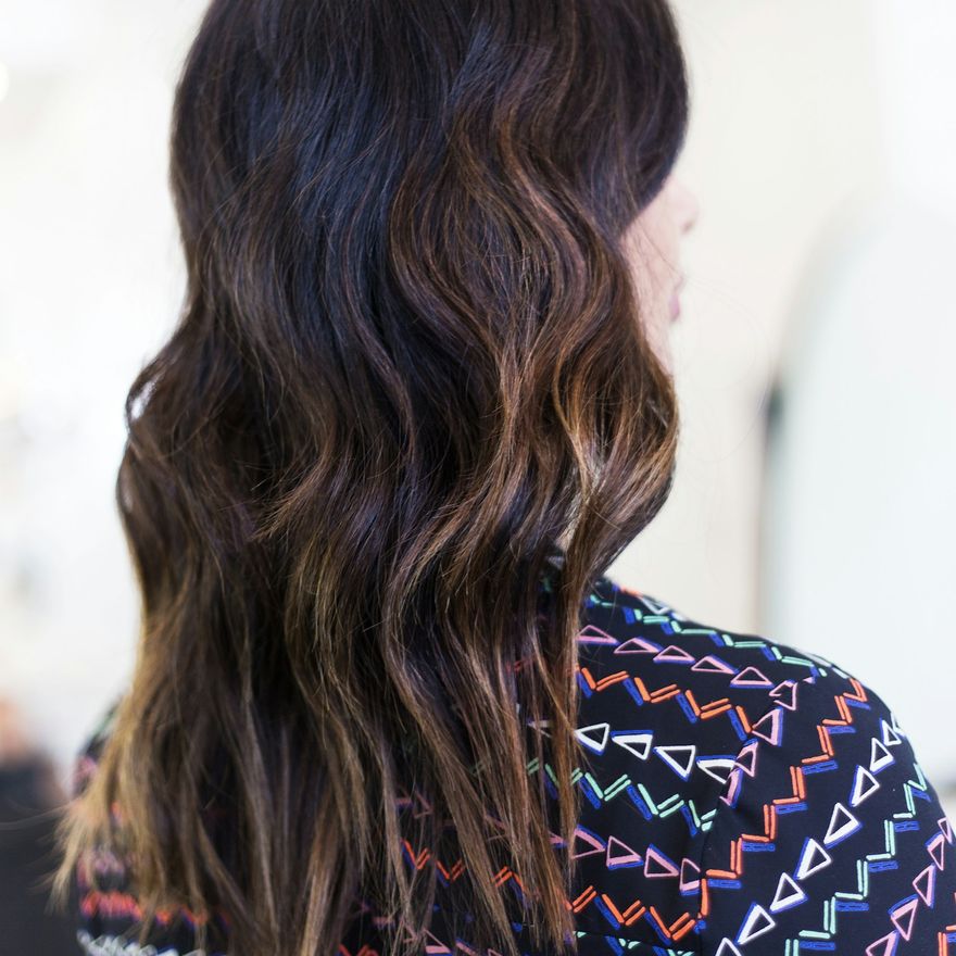 Dark brown hair with warm balayage in loose waves